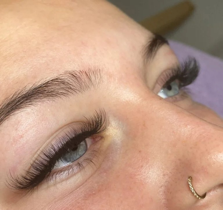 Nahaufnahme voluminöser Wimpern und definierter Brauen